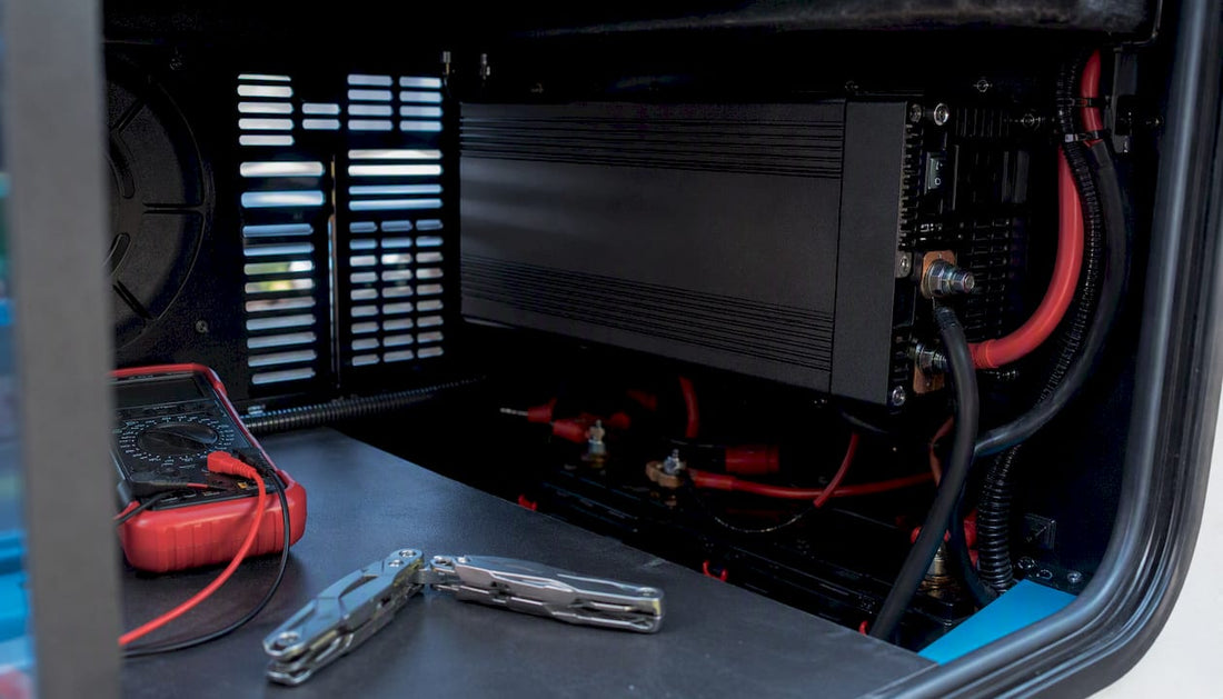 RV inverter connected to battery bank in compartment