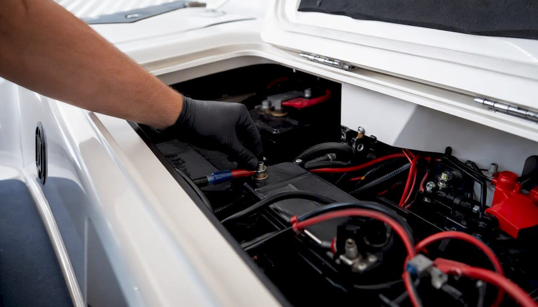 Gloved hand wiring marine battery terminals