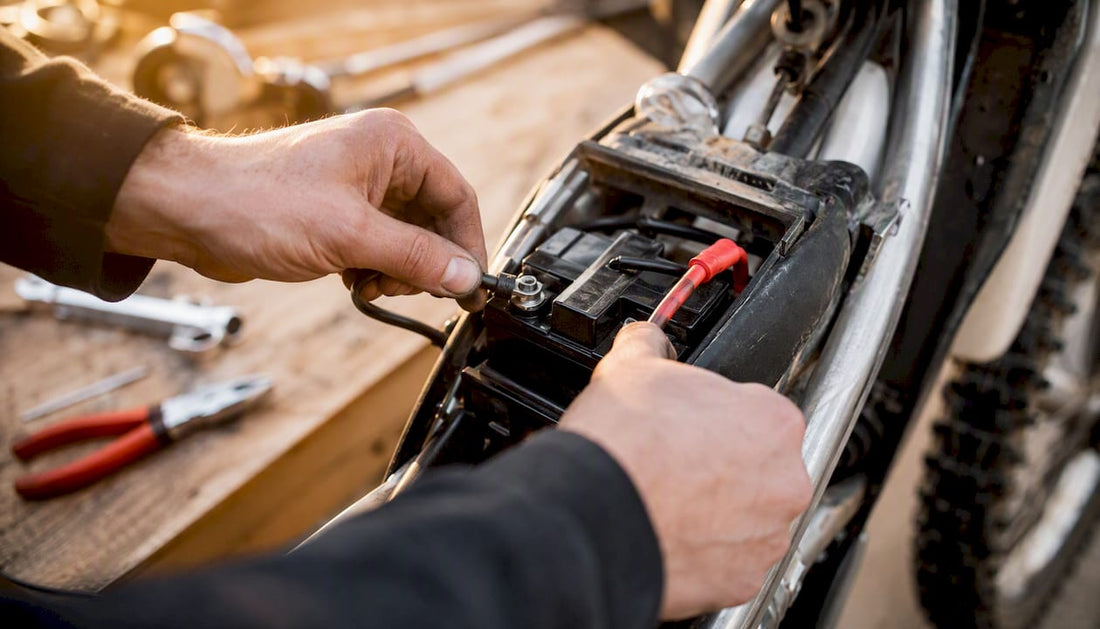 Hands installing dirt bike battery in compartment