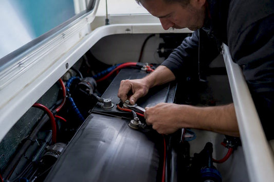 Hands inspecting swollen marine battery terminals