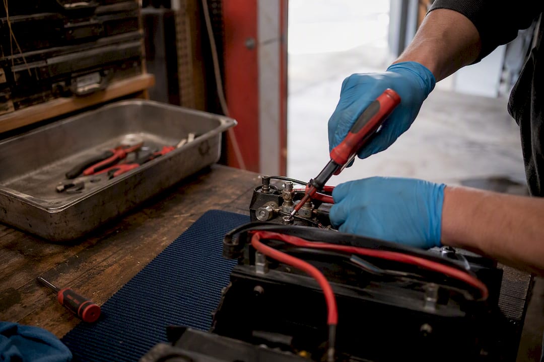 Hands disconnecting battery terminals safely