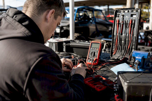 Hands testing lithium battery voltage