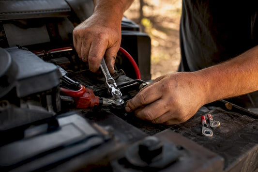 Hands wiring dual battery cables in vehicle